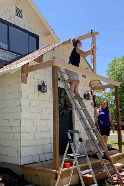 Using a level to set the ridge board while framing a gable porch roof