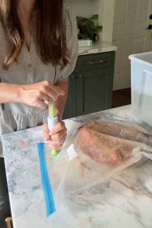 Crystel using the hand pump on the bag valve to draw the air out before cooking the sous vide chuck roast