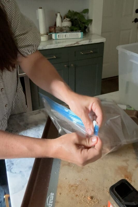 Crystel sliding the clip along the top of the bag to seal a seasoned chuck roast for the sous vide method