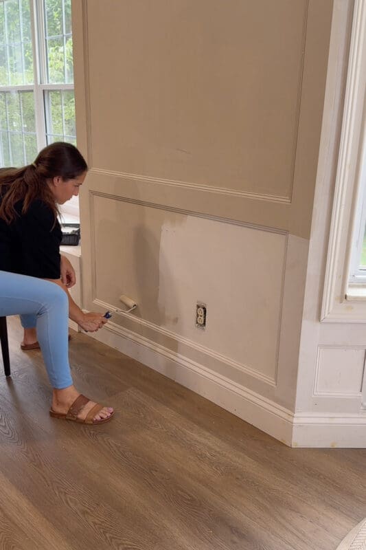 Crystel rolling Sherwin Williams Accessible Beige paint over the wall and picture frame trim beside the finished window bench
