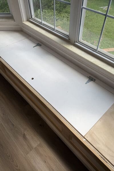 The bay window bench with storage fully trimmed out and ready for primer, with the hinged lift top, finger hole pull, and picture frame molding front