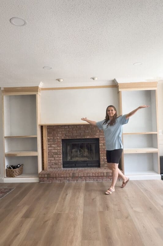 Crystel with the raw plywood built ins and crown molding complete, before the DIY fireplace surround trim and paint were added