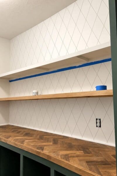 floating pantry shelves being primed and painted white with painter's tape on the wall